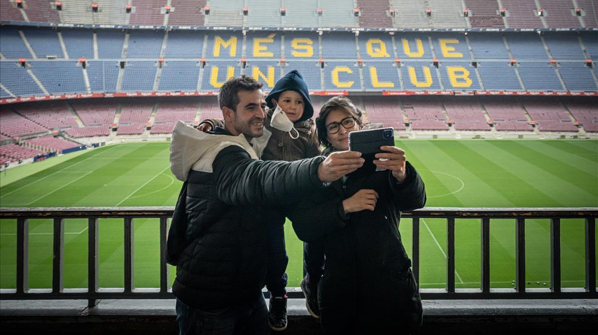 Una familia se hace un 'selfi' durante la visita al museo con el Camp Nou al fondo.