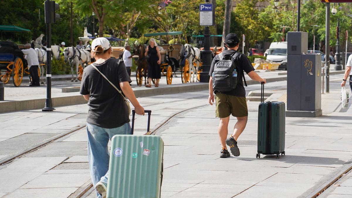 Turistas con maletas y equipaje en el centro de Sevilla