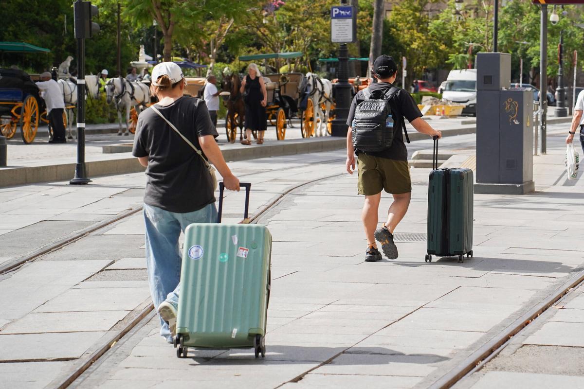 Turistas con maletas y equipaje en el centro de Sevilla