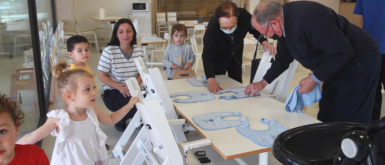 Los mayores comparten acciones y espacios con los pequeños, por ejemplo colocando los baberos en el comedor.