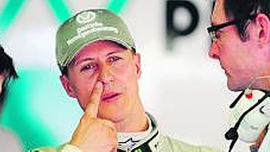 Michael Schumacher charla con dos ingenieros de Mercedes durante el pasado fin de semana en Montecarlo. / efe