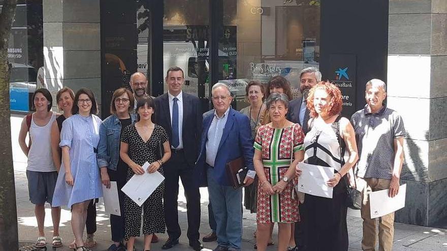 En el centro, con corbata, el director territorial de CaixaBank, Emilio Barreiro, con representantes de las ocho entidades.