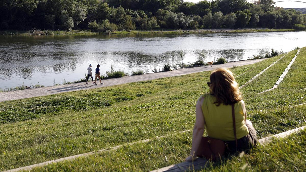 Una mujer mira al Ebro desde la zona Expo