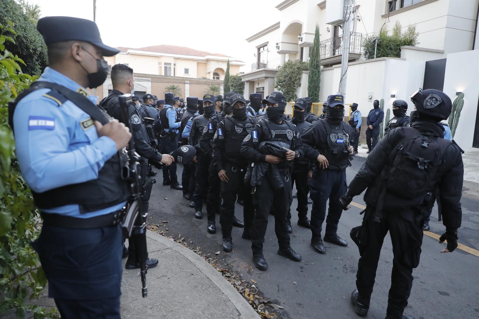 Agentes de policía y periodistas esperan en las afueras de la casa del expresidente Juan Orlando Hernández en Tegucigalpa (Honduras).