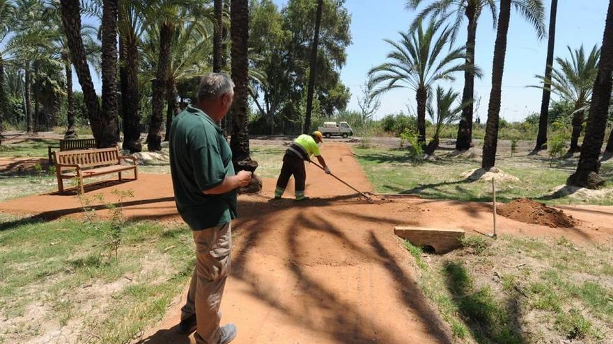 Dos operarios arreglan los caminos por los que se puede pasear. JUAN