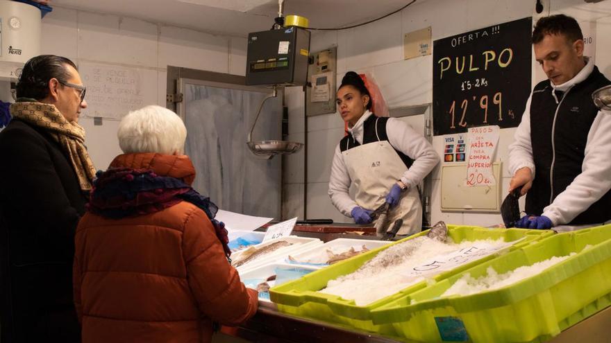 Dos clientes siendo atendidos en la pescadería. |