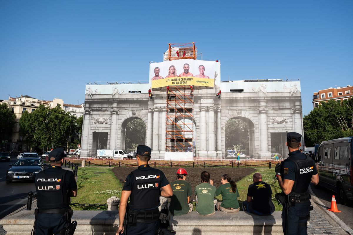 Activistas de Greenpeace han colgado hoy una pancarta en la Puerta de Alcalá