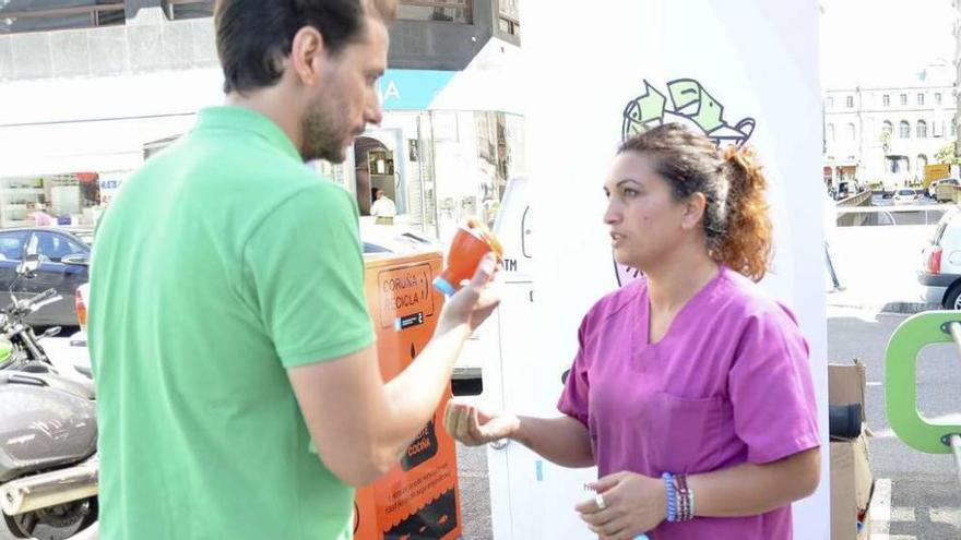 Una de las Mulleres Colleiteiras entrega un embudo a un usuario de la plaza de Lugo, con el contenedor al fondo.