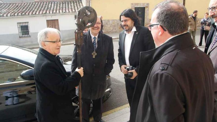 El obispo recibe el báculo de madera de manos de los miembros de la directiva de la cofradía.