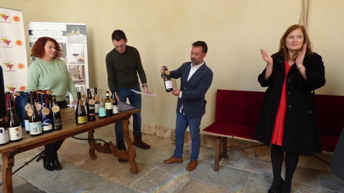 El presidente de la DOP, José María Martínez, destapa uno de los vinos premiados, a su lado la directora general Begoña López y el director de Gustatio David Fernández-Prada.
