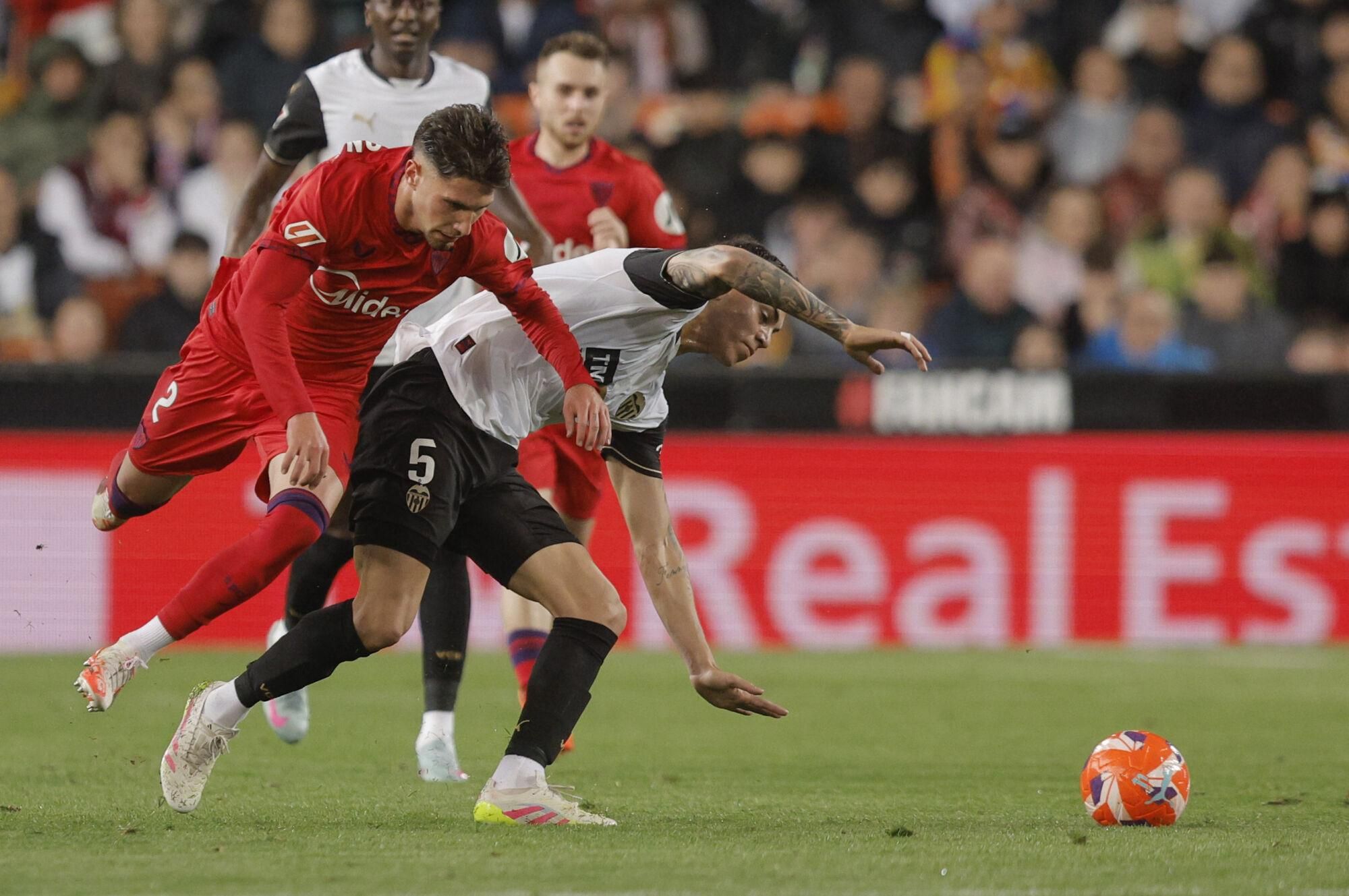 VALENCIA, 11/04/2025.- El centrocampista argentino del Valencia Enzo Barrenechea (d) disputa el balón con el defensa del Sevilla José Ángel Carmona durante el partido de Liga disputado este viernes en el estadio de Mestalla. EFE/Kai Forsterling