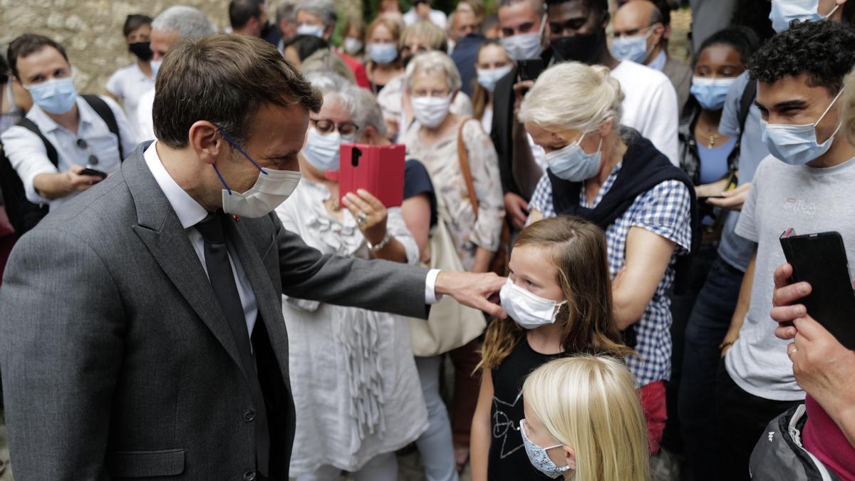El presidente francés, Emmanuel Macron, saluda a unas niñas