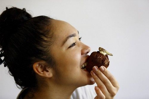 Keiko Chavers tastes a chocolate cupcake made of mealworms and topped with a locust at the Cooking school at the University of Wageningen