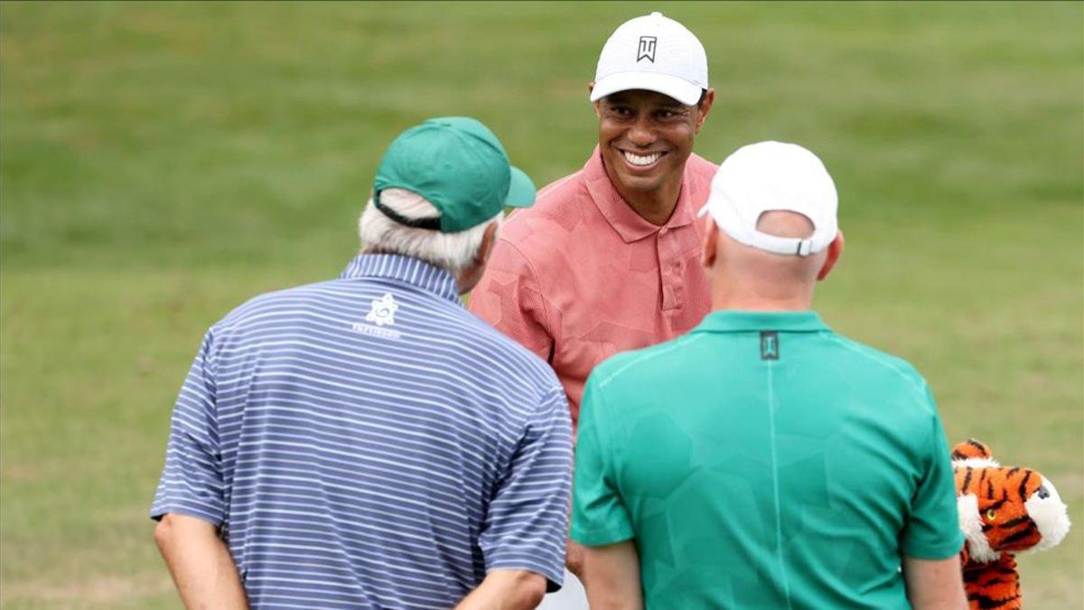 Tiger conversa con Fred Couples, y su caddie, Joe LaCava, en la zona de prácticas