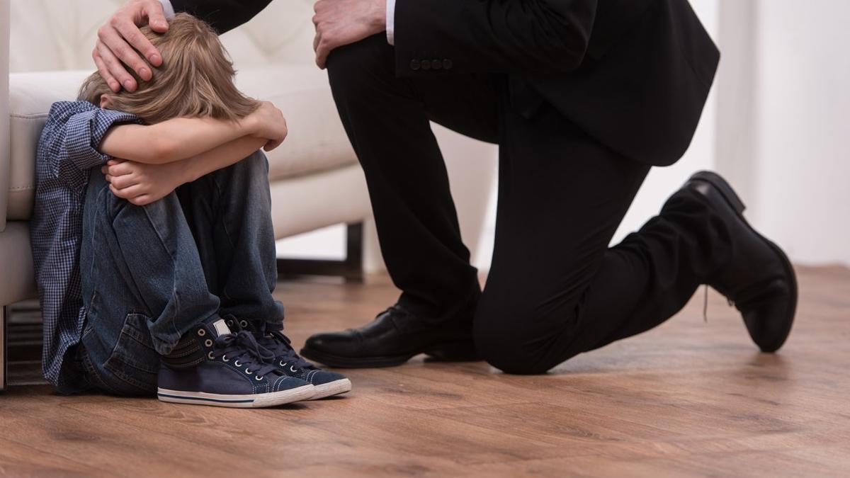 Un padre consuela a su hijo que está llorando