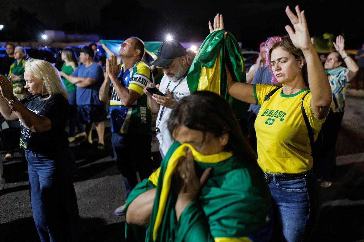 AME1762. BRASILIA (BRASIL), 22/11/2025.- Simpatizantes del expresidente de Brasil, Jair Bolsonaro, participan en una vigilia de oración este sábado, cerca de la casa del exmandatario, en Brasilia (Brasil). La prisión preventiva de Bolsonaro, dictada por la Corte Suprema, ha dejado dos imágenes radicalmente opuestas en Brasilia: una vigilia a favor de su libertad y una fiesta con derecho a batucada para celebrar su arresto. EFE/ Isaac Fontana