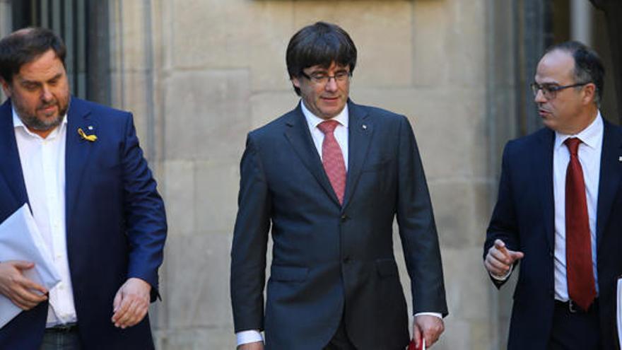 Puigdemont, flanqueado por Turull y Junqueras.