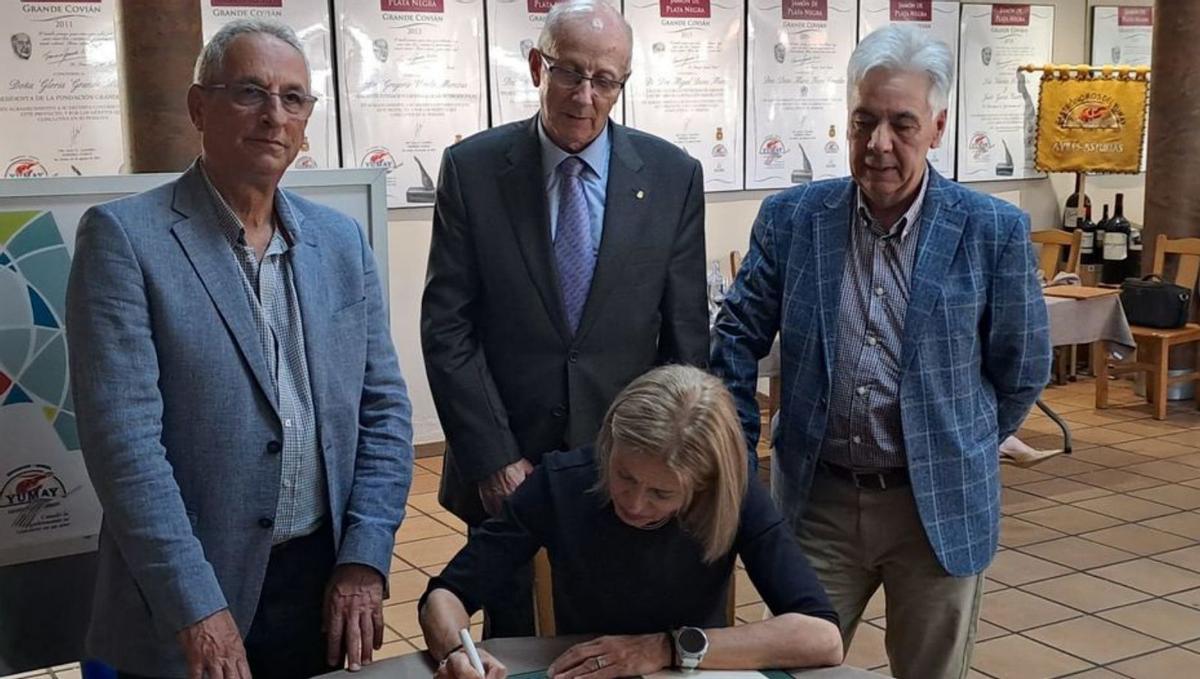 Los comisarios José María Esteban Corral, Agapito Pérez y Alejandro Valverde tras Inmaculada Leis, durante la firma en el libro de honor del Yumay. |
