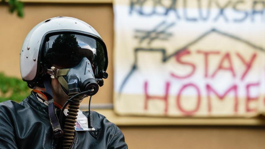 Un hombre se manifiesta en Berlín con casco y mascarilla.