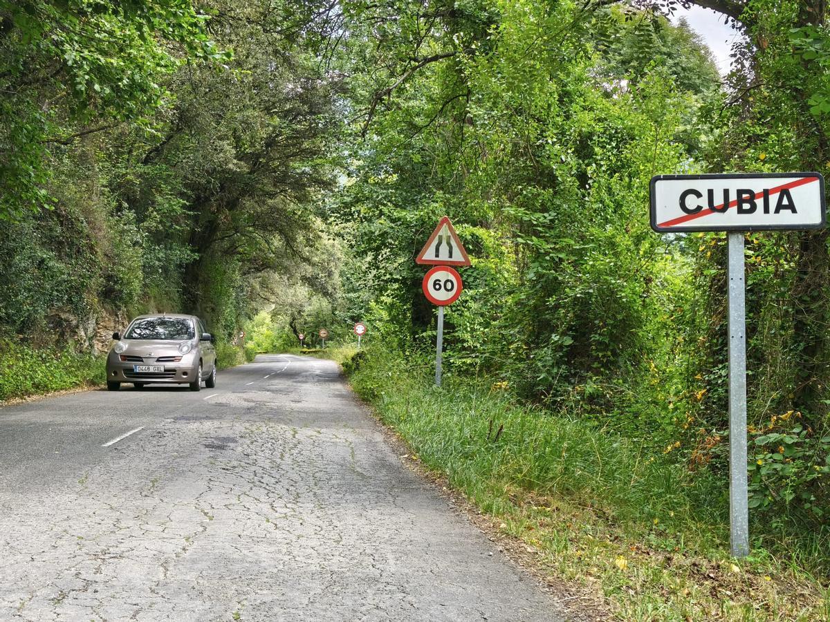 Un vehículo entra en la localidad de Cubia, en Grado, con un gran hundimiento en el carril derecho.