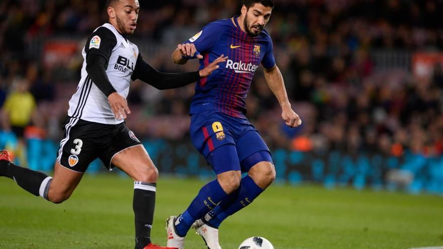 El portugués Rubén Vezo, con el Valencia, defiende un ataque del barcelonista Suárez. // Josep Lago | AFP