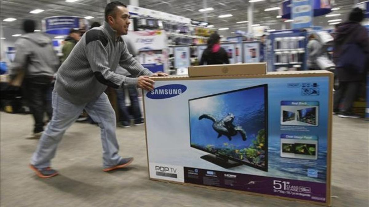Un ciutadà compra un televisor en un comerç dels EUA. Un ciutadà compra un televisor en un comerç dels EUA.
