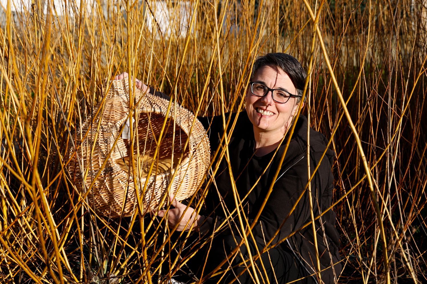 Julia entre los mimbres que cultiva.