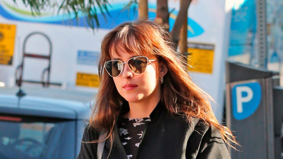 El uniforme de invierno de Dakota Johnson: vaqueros rectos, abrigo negro y bolso de Celine