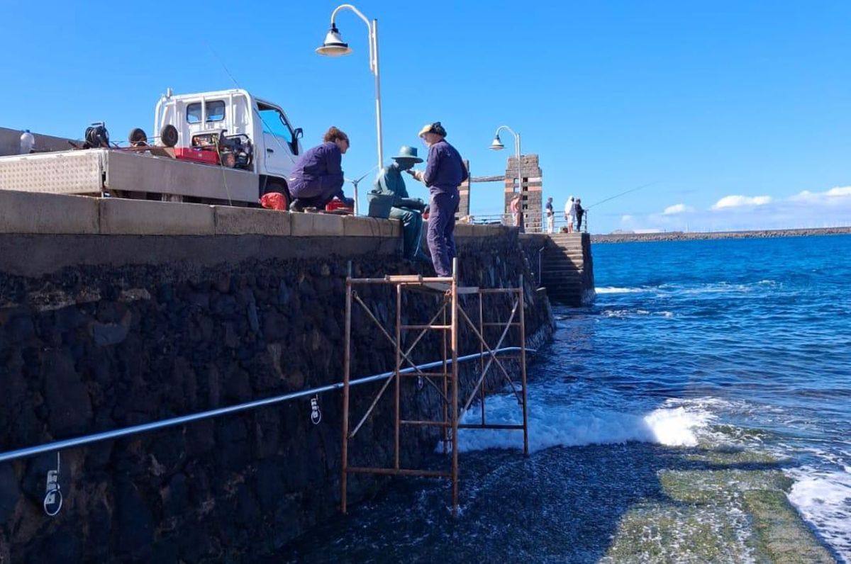 Imagen reciente de operarios reponiendo la caña a la obra de Suárez, el Pescador, que ha sido rota ya en cuatro ocasiones.CAÑA PESCADOR BUENA COLOCAN JPG
