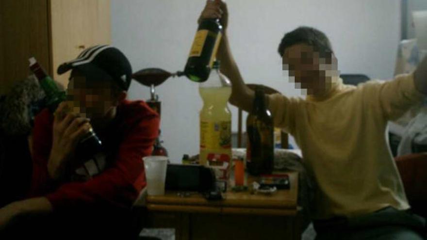 El menor acusado de los atracos besa una botella de whisky junto a un amigo en una imagen colgada en Tuenti.
