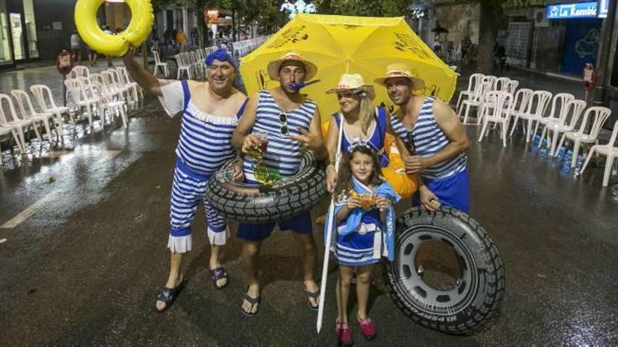 Aunque la lluvia aguó la fiesta a los peñistas de Sant Joan d&#039;Alacant, algunos no dejaron que ello les robara la sonrisa, como este grupo ataviados con bañadores antiguos.