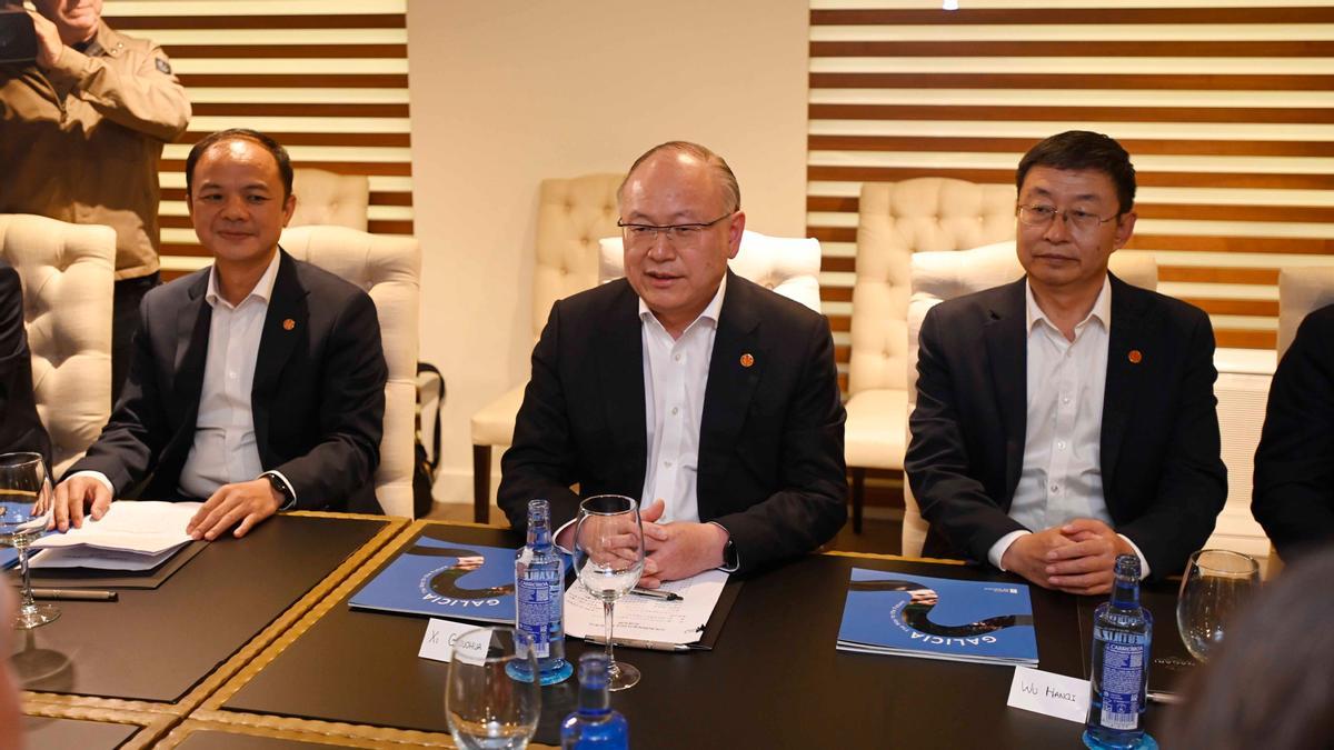 Xi Guohua, entre dos altos cargos del grupo.