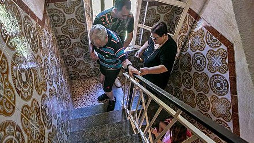 Una persona mayor subiendo escaleras con ayuda de familiares, en imagen de archivo.