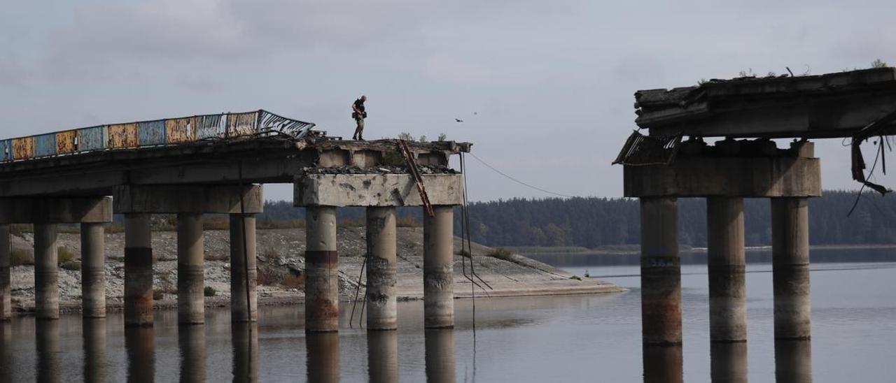 Un soldado ucraniano supervisa un puente dañado sobre el río Donets, en la región de Járkov.