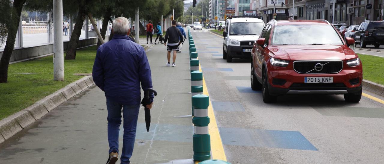 Peatones caminando ayer por la senda peatonal junto al «cascayu», a la derecha, ya abierto al tráfico. | Ángel González