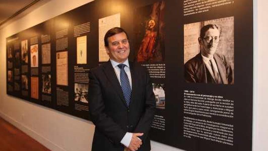 Javier Such en la exposición del Rectorado, junto a una foto de su abuelo Miguel Such.