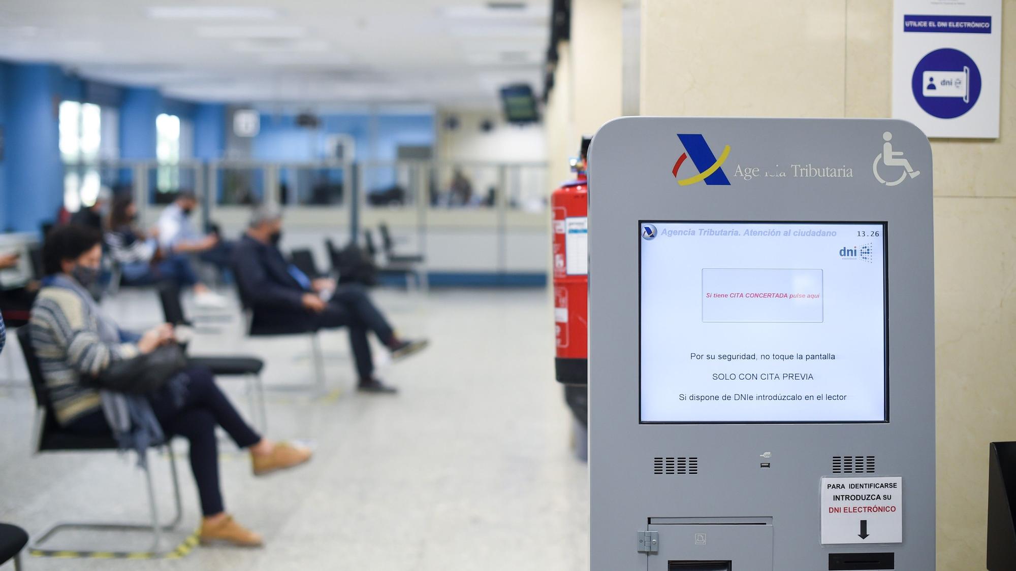 Varias personas esperan en la Agencia Estatal de la Administración Tributaria, en Madrid.