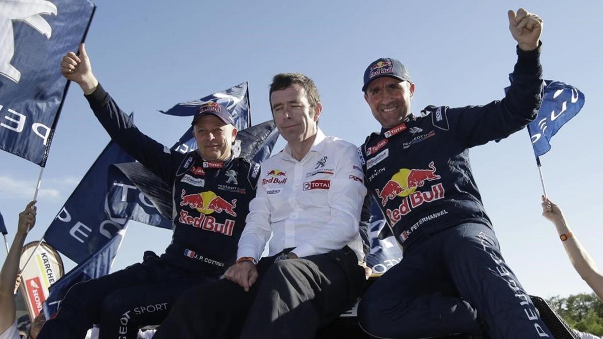 Stéphane Peterhansel, a la izquierda, junto al jefe de Peugeot, Bruno Famin, y su copiloto Jean Paul Cottret.