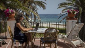 Una mujer teletrabaja desde la playa.