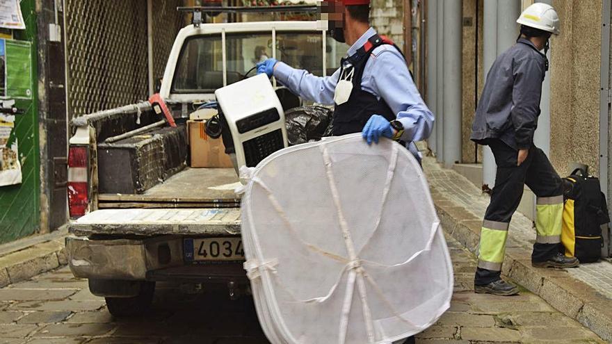 Un agent posa material comissat en un vehicle de la brigada municipal