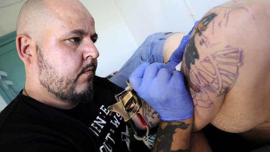 Rodrigo Ces facendo unha tatuaxe no Gastrobar Doña Maruja. // Bernabé/Javier Lalín