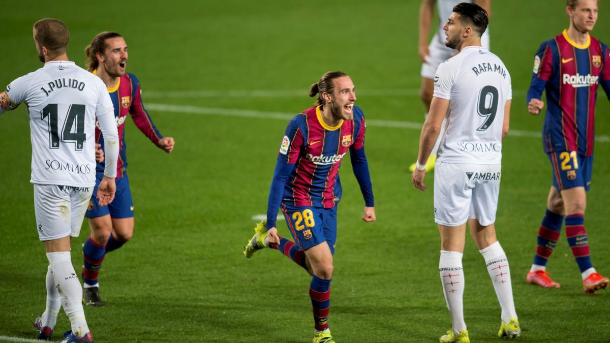 Mingueza corre alborozado, perseguido por Griezmann, tras marcar su primer gol como profesional ante el Huesca.