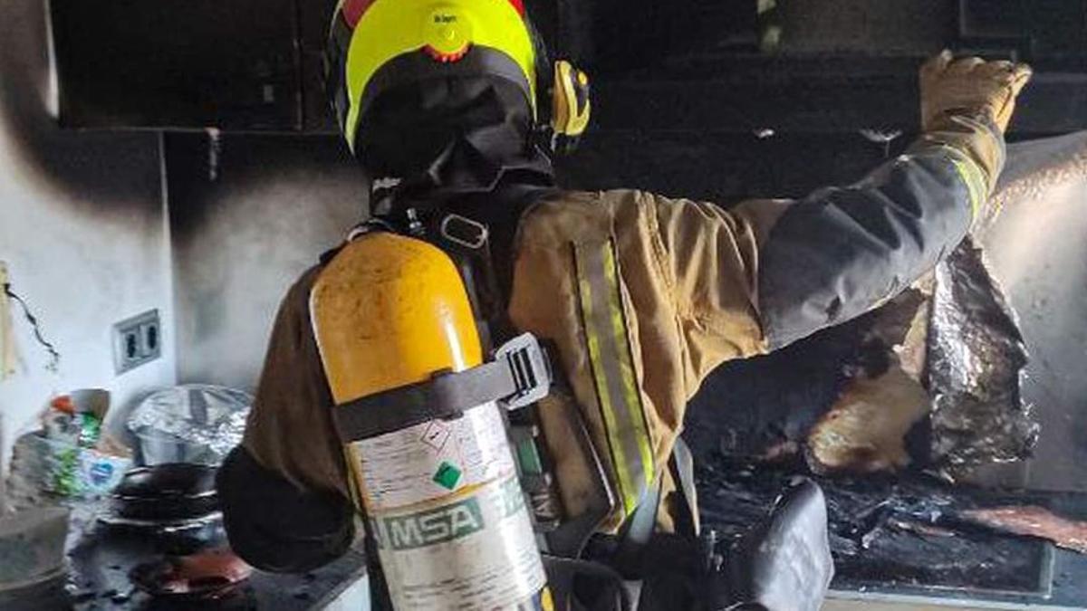 Imagen de archivo de un bombero revisando los daños de un incendio en una vivienda.