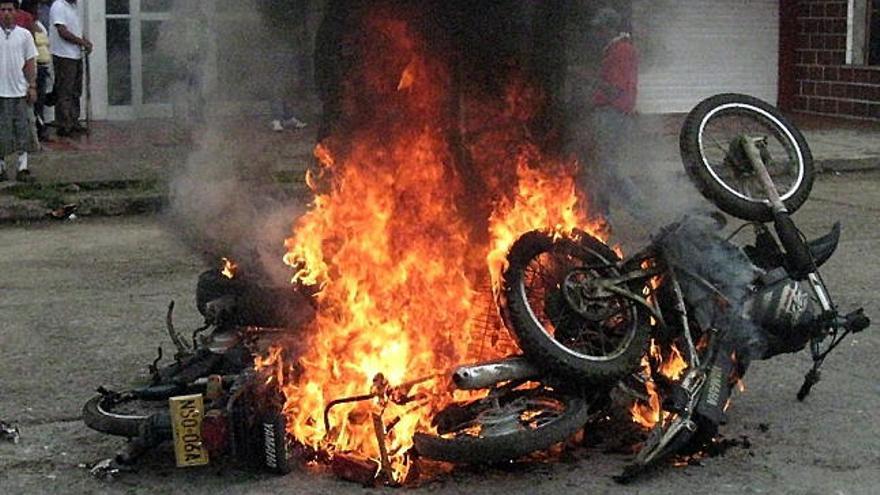 De talle de unas motocicletas incineradas después de que las sedes de dos &quot;pirámides&quot; financieras en Mocoa, capital del departamento colombiano de Putumayo, fronterizo con Ecuador y Perú, fueron saqueadas.