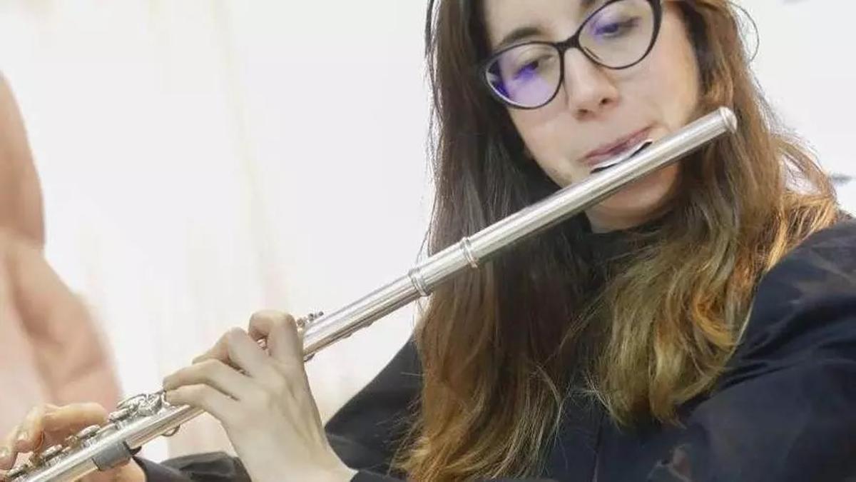 Una joven interpreta una pieza a la flauta durante una actuación musical.
