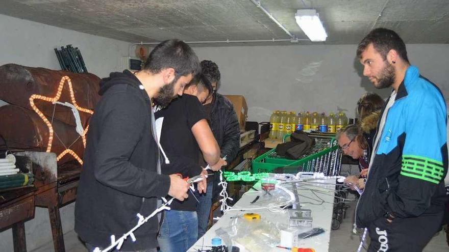 Integrantes de la comisión de fiestas y colaboradores, construyendo el árbol en un almacén.