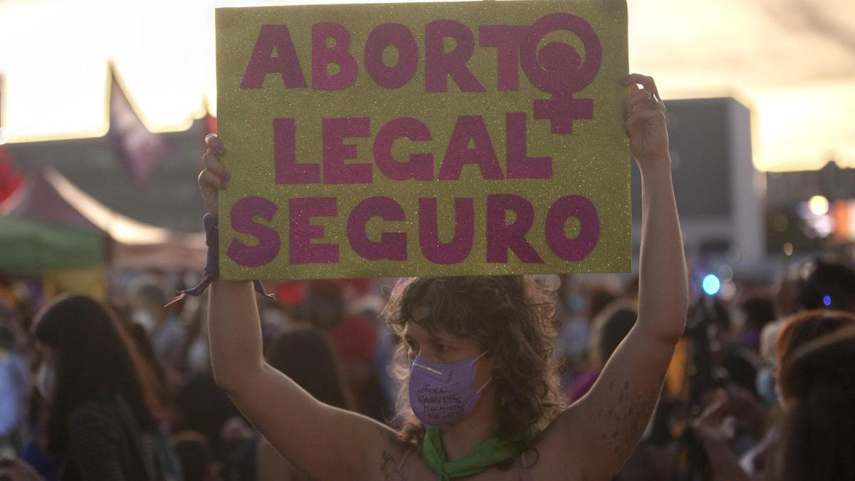 Una mujer sostiene un cartel a favor del aborto legal.