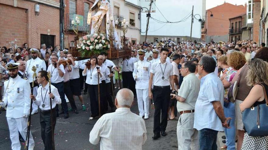 La Virgen del Carmen, flanqueada por la Armada Española, seguida de los feligreses.