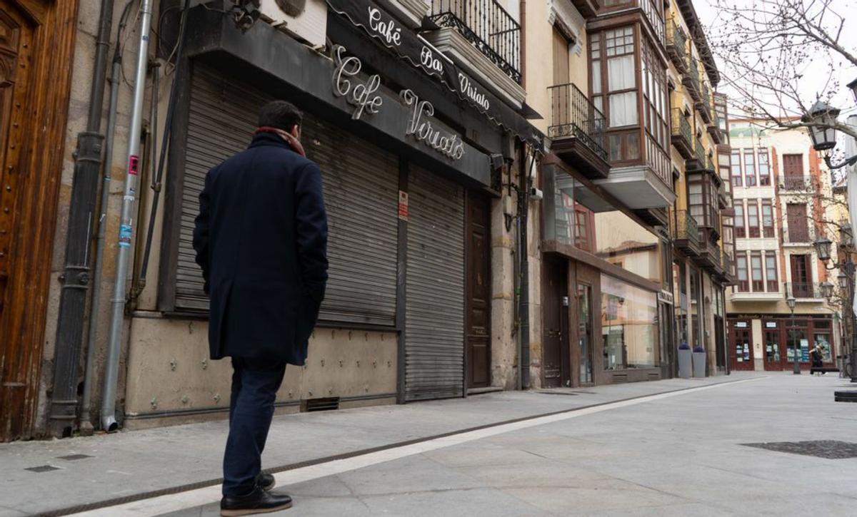 Arriba, el letrero de García Casado, conservado tras la rehabilitación. Sobre estas líneas, Javier García Martín (izquierda) y local de La Casa de las Lanas, donde han hecho estragos los vándalos. | |  JOSE LUIS FERNÁNDEZ  Y CEDIDA