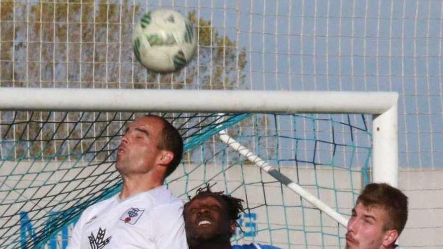 Un defensor de la UD Toresana despeja un balón aéreo.